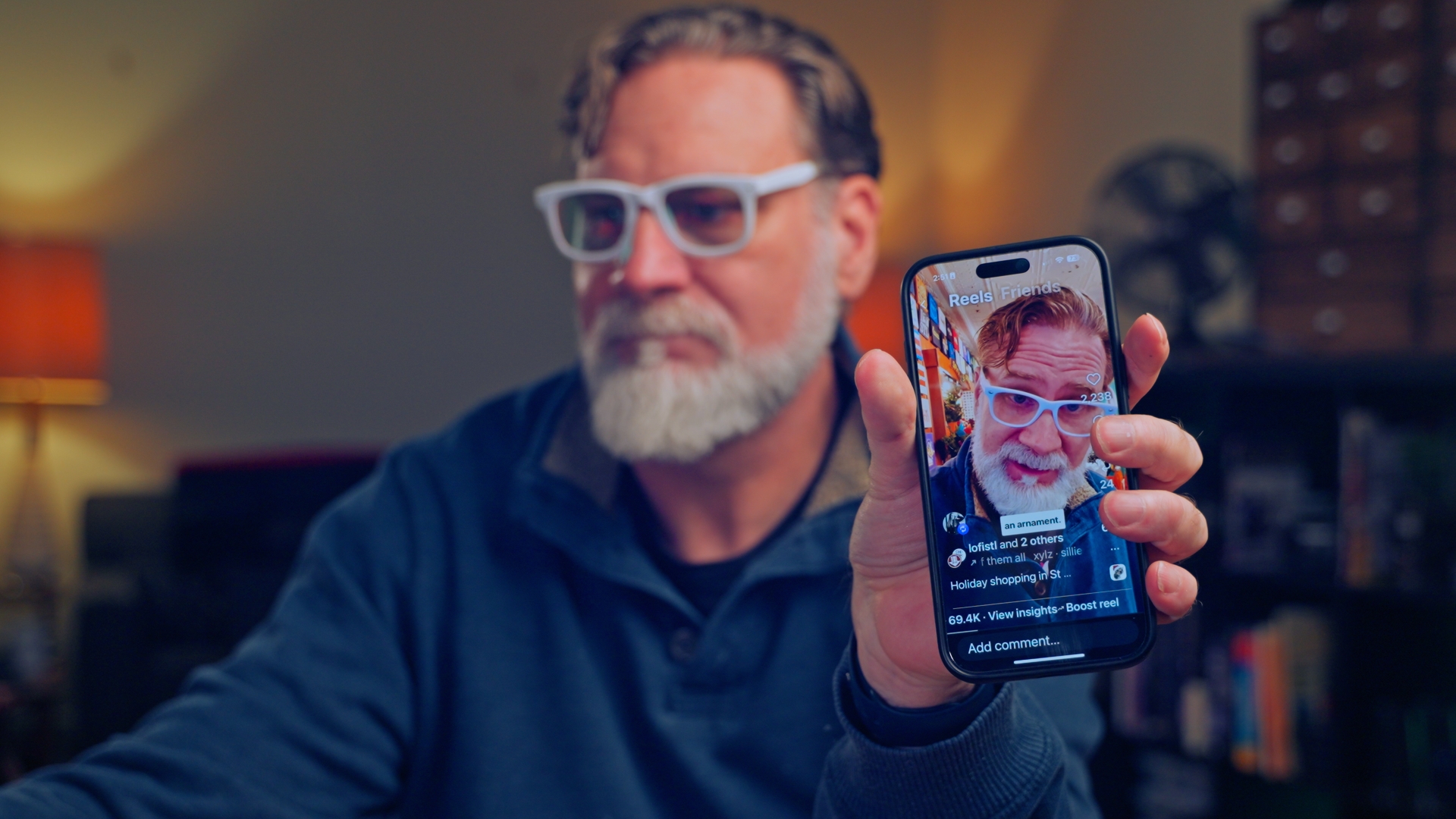 Bill Streeter holding a phone displaying one of his videos